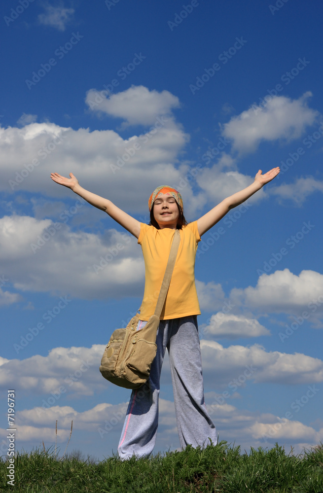 Girl holding hands up against blue sky Girl holding hands up against blue sky