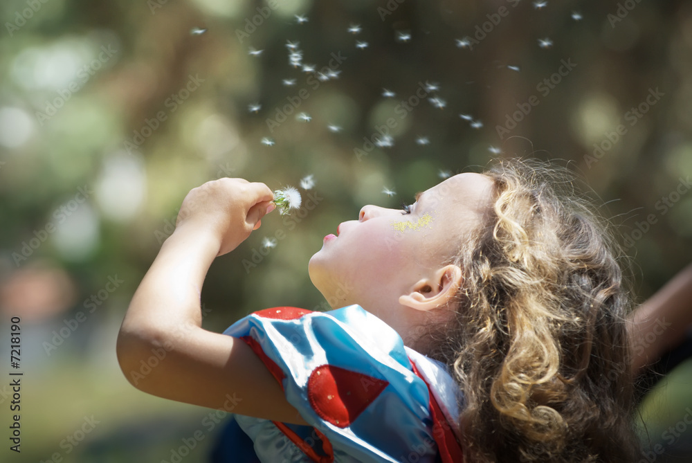 Naklejka premium Young girl blowing dandelion