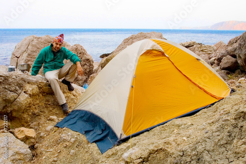 Man near a tent ashore sea