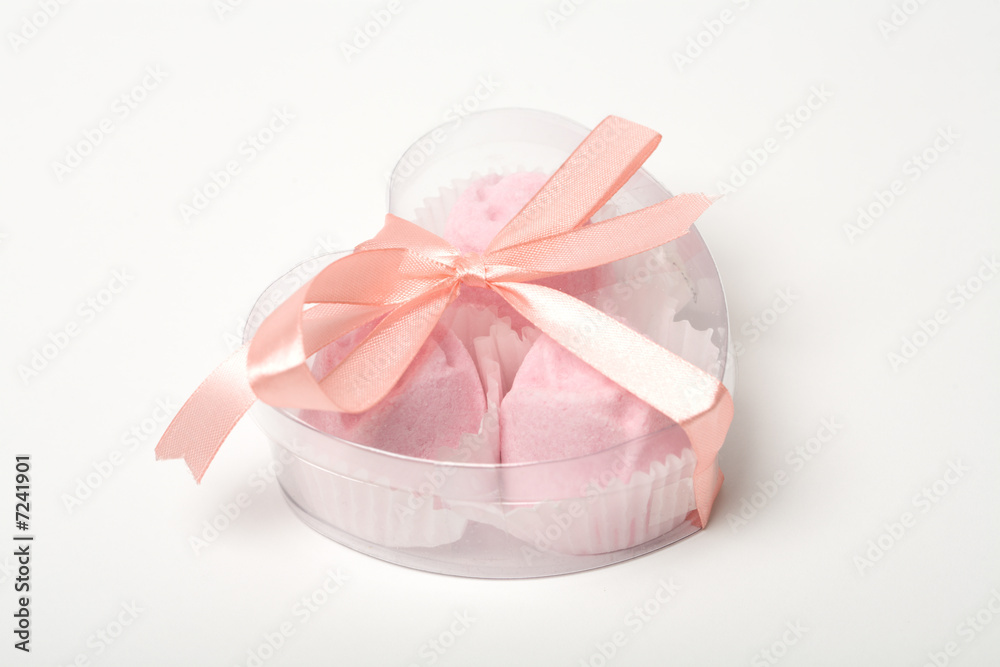 Little pink cakes in a heart shaped box over white Little pink cakes in a heart shaped box over white