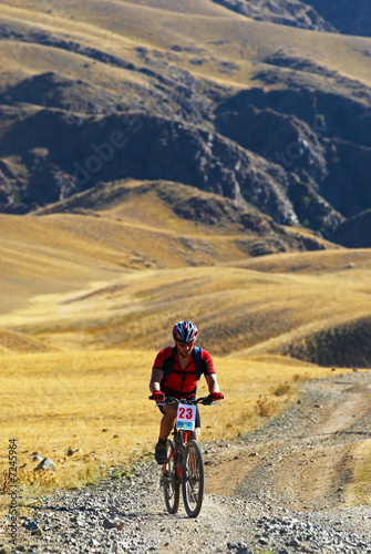 Mountain biker racing on old road in desert