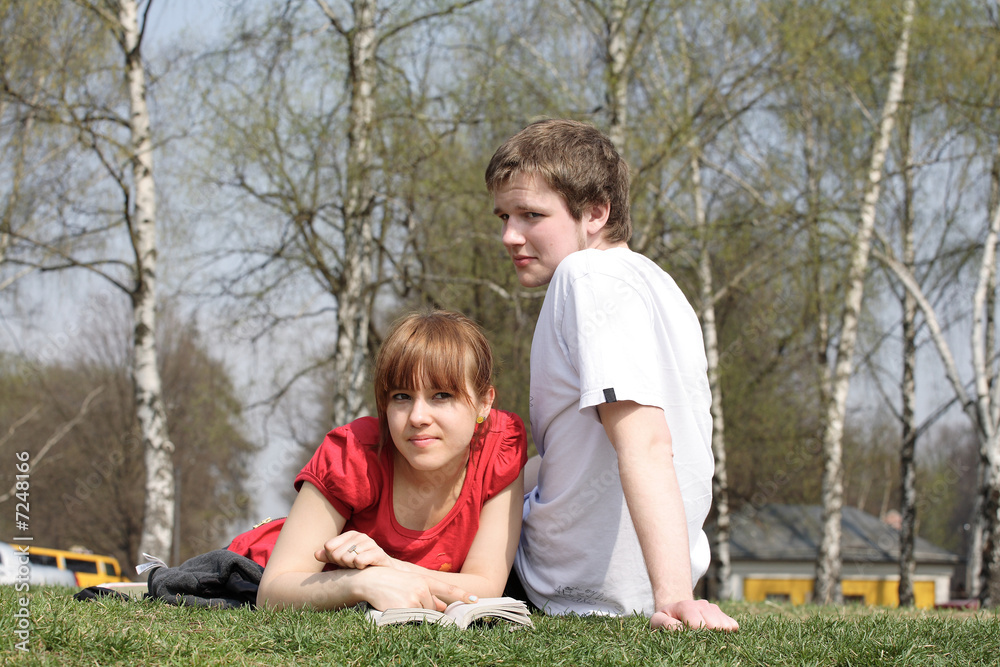 Friends. The young man and the girl sit on a grass in park. Friends. The young man and the girl sit on a grass in park.