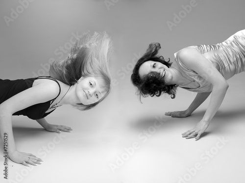 Two girls get down and smiling