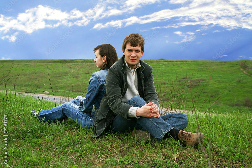 Guy and girl sits on a grass