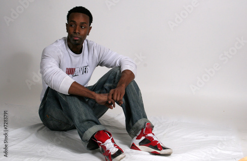 Obraz na plátně Young black man sitting down on floor