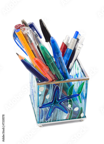 Glass pen holder with pens, isolated on white