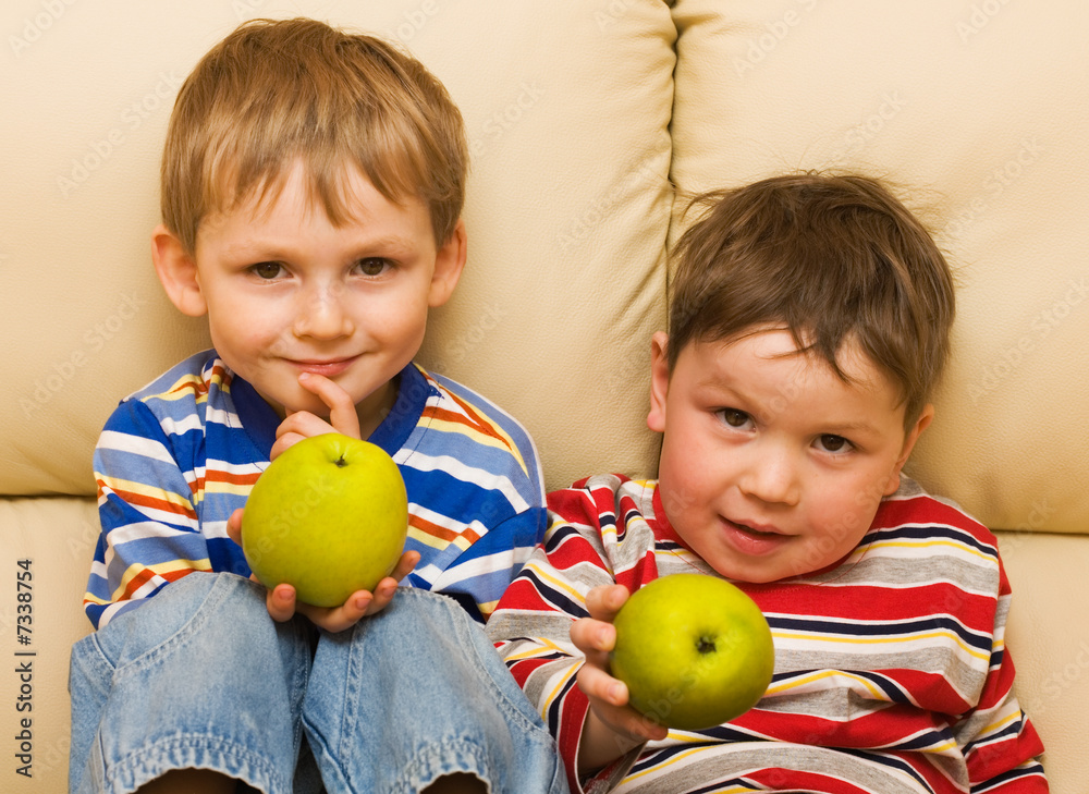 Fototapeta premium Two funny kids show an apple