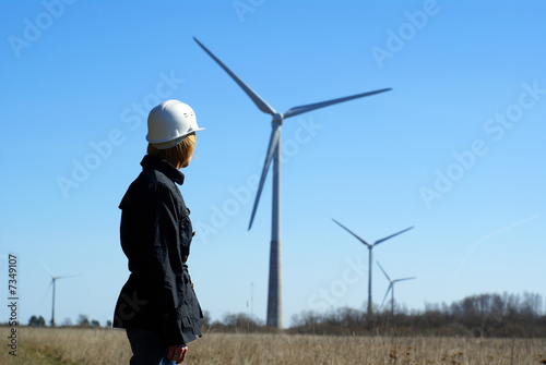 Woman engineer or architect with white safety hat and wind turbi