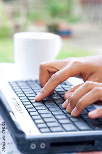 A pair of feminine hands at the computer keyboard