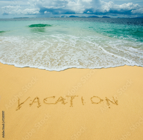 vacation written in a sandy tropical beach