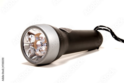 a black flashlight torch on a white seemless background.