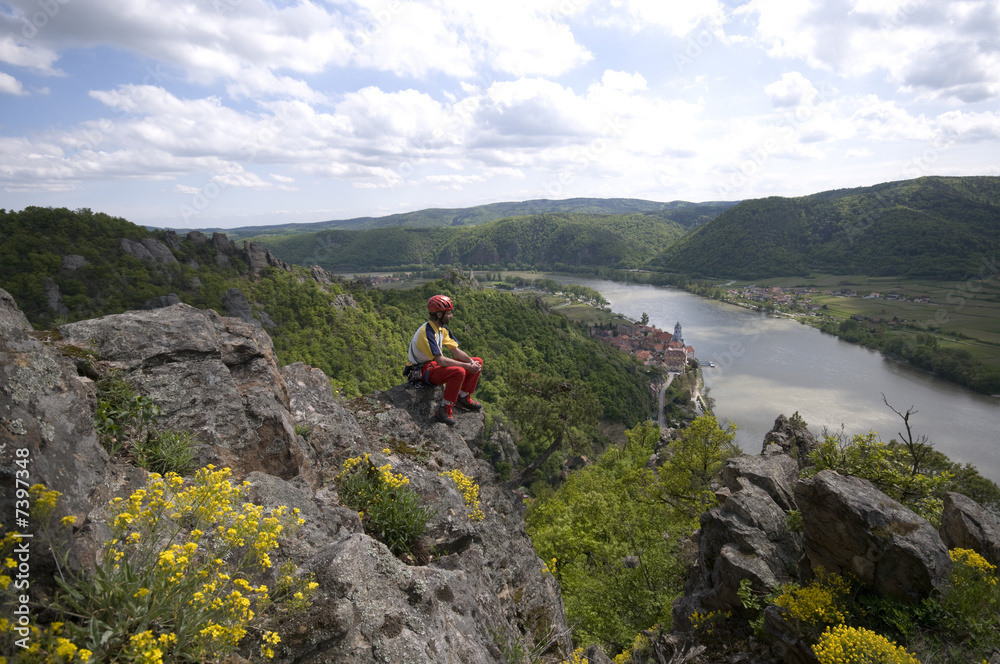 Bergsteiger rastet auf einem luftigen Felsen über dem Donautal