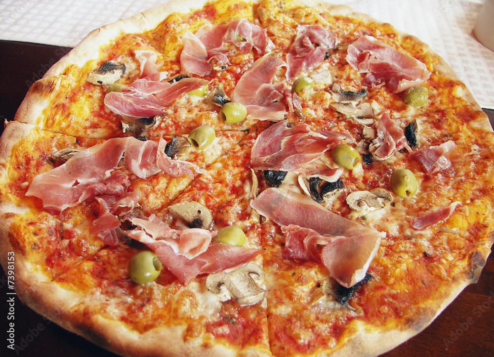 Italian pizza with italian ham, olives and field agaric.