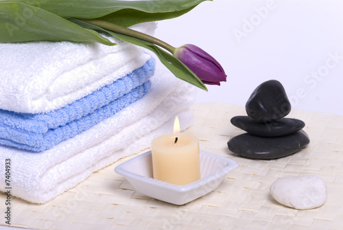 Candle, stones, towel and flower.
