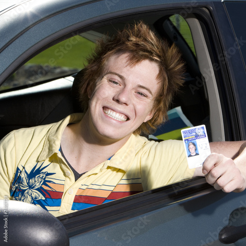 Happy teen in car with licence photo