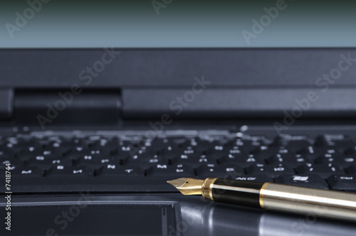 Fragment of laptop with a pen