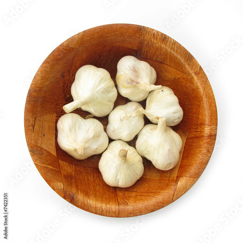 Garlick in wooden dish isolated on white