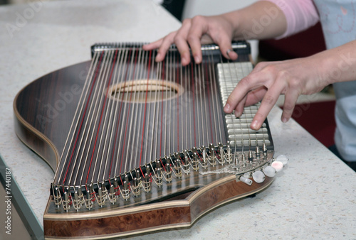 Detail of playing on zither musical instrument.