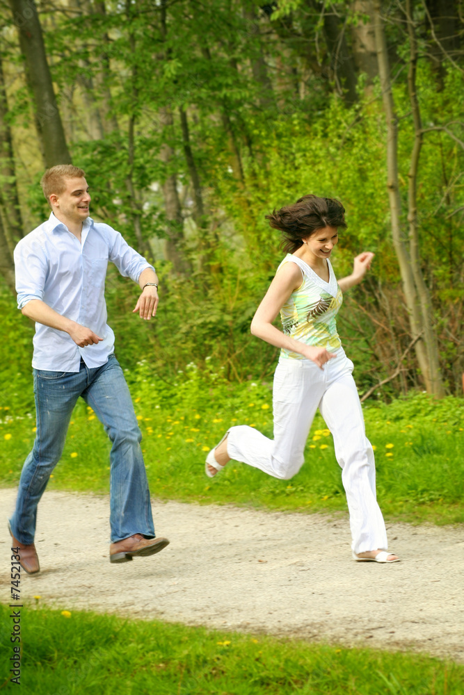 young couple is running on a way