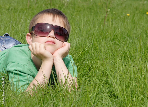 little boy having a rest on young grass