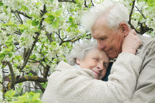 happy grandparents against a background of flowering garden