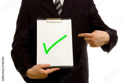 Green tick on clipboard in the hand of a businessman