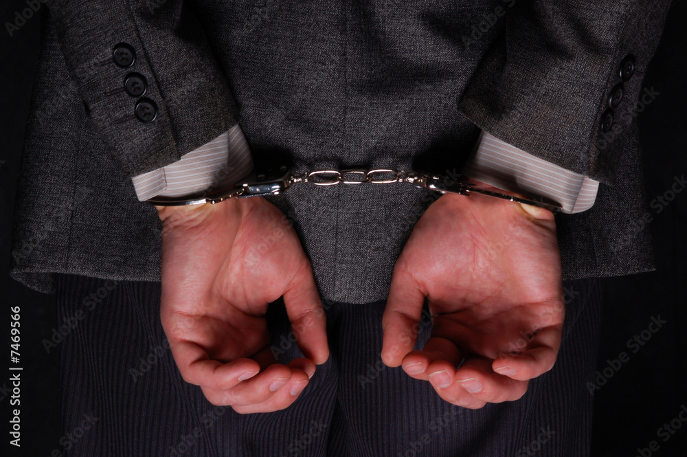 Arrested businessman handcuffed hands at the back