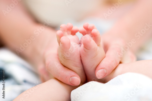 Mother gently massage baby's legs
