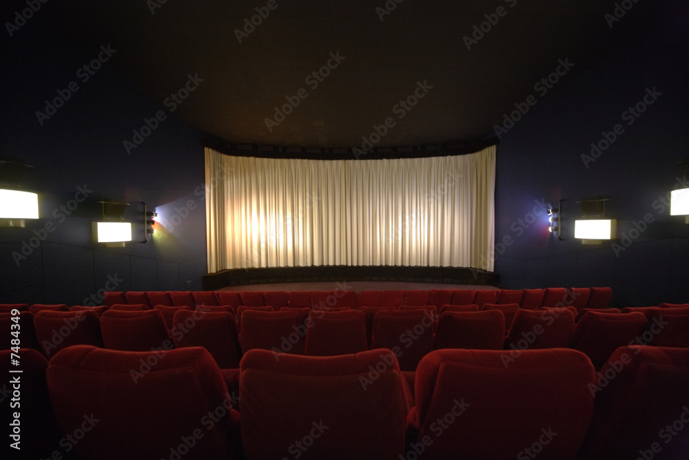 Rows of chairs in a cinema with the curtain drawn