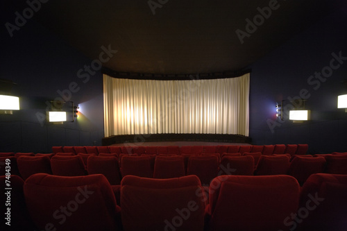 Rows of chairs in a cinema with the curtain drawn