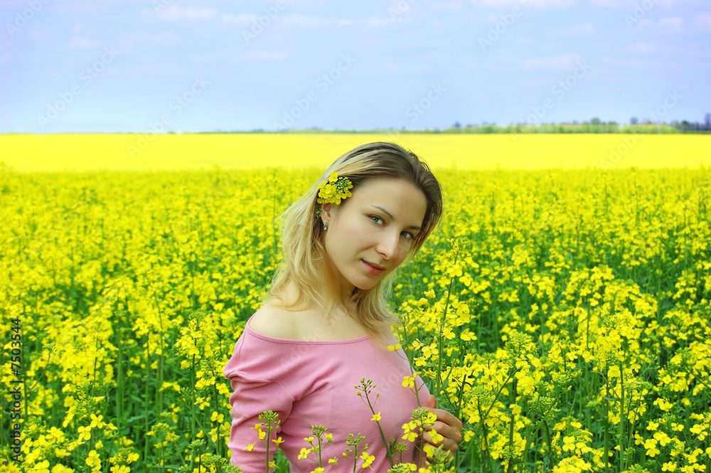 Beautiful girl among blooming rape oilseed field Beautiful girl among blooming rape oilseed field
