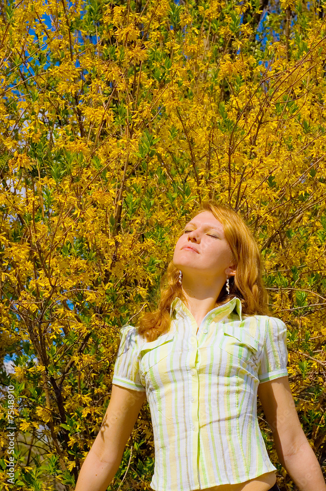 Girl posing near yellow flowers tree