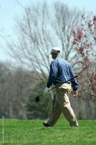 Male golfer walking on a golf course