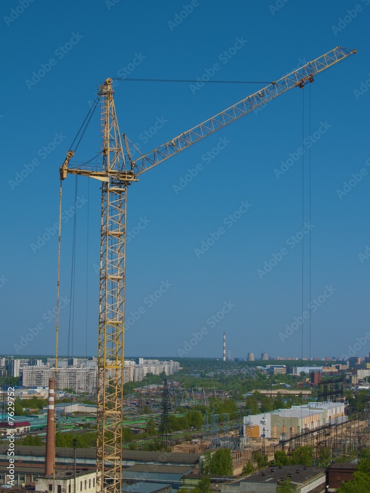 City landscape with yellow crane erecting