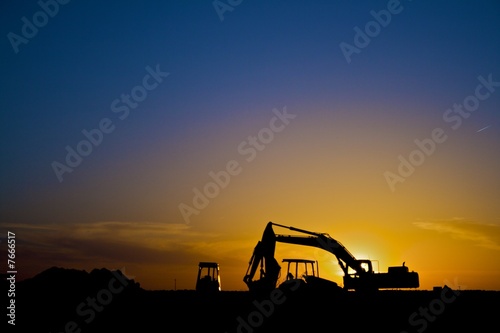 Construction equipment in silhouette, horizontal