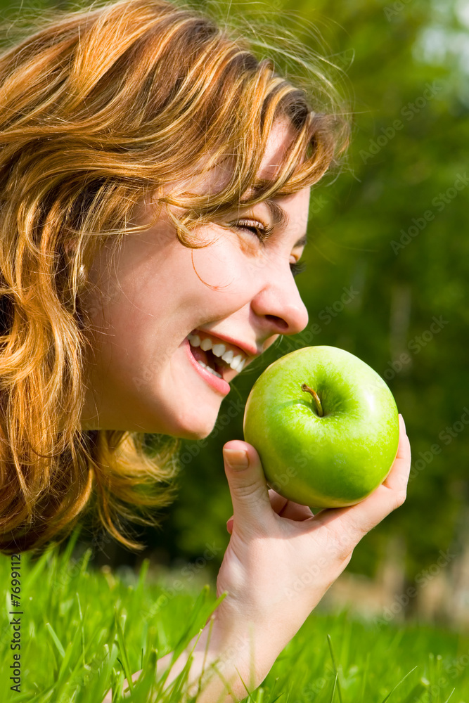 pretty woman eating green apple on the summer glade pretty woman eating green apple on the summer glade