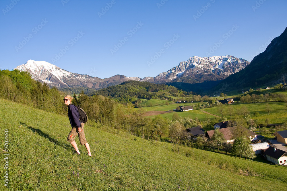 young female on a meadow in the mountainous landscape