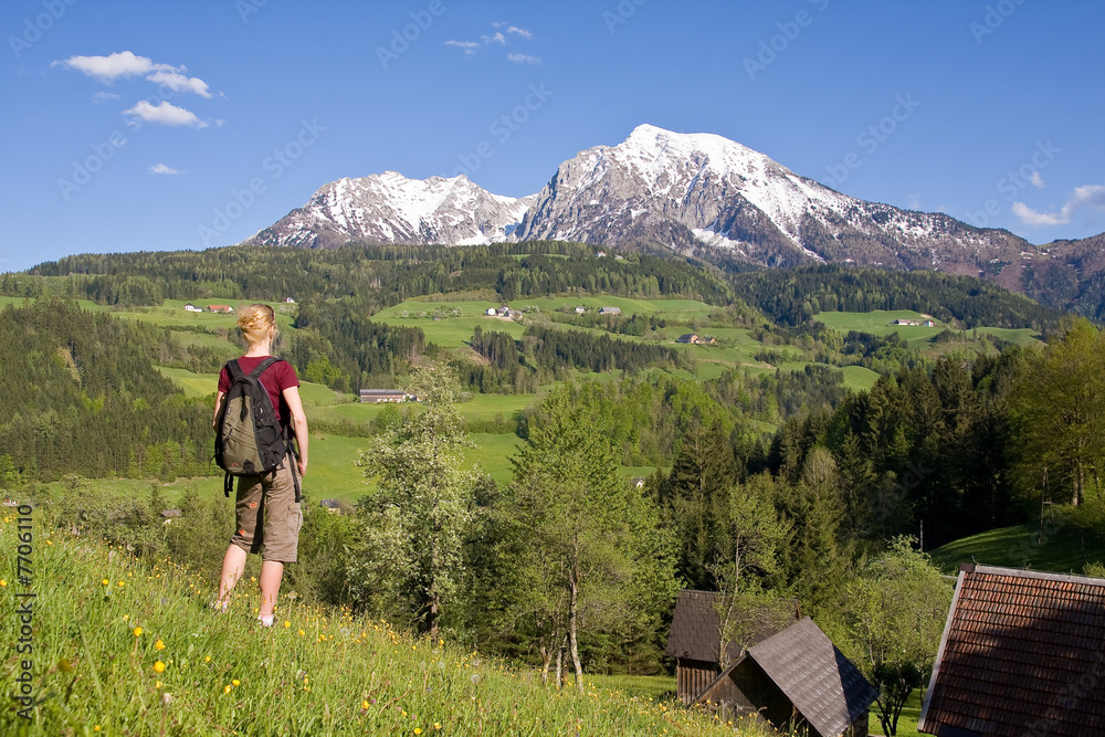 young female on a meadow in the mountainous landscape