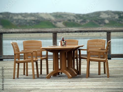 Empty chairs and table setting outdoor deck
