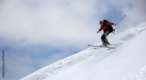 Skier jumping from the edge of snow ridge