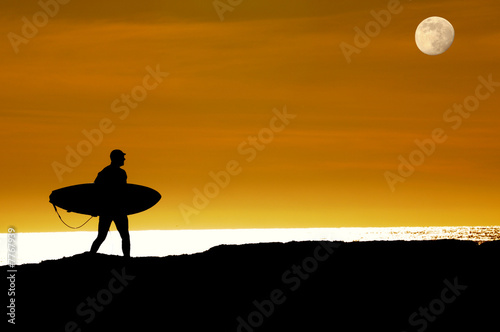 Surfer walking on cliffs to last ride