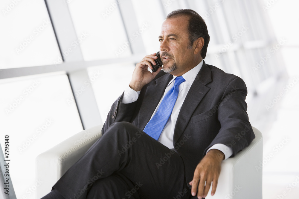 Businessman talking on mobile phone in lobby Businessman talking on mobile phone in lobby