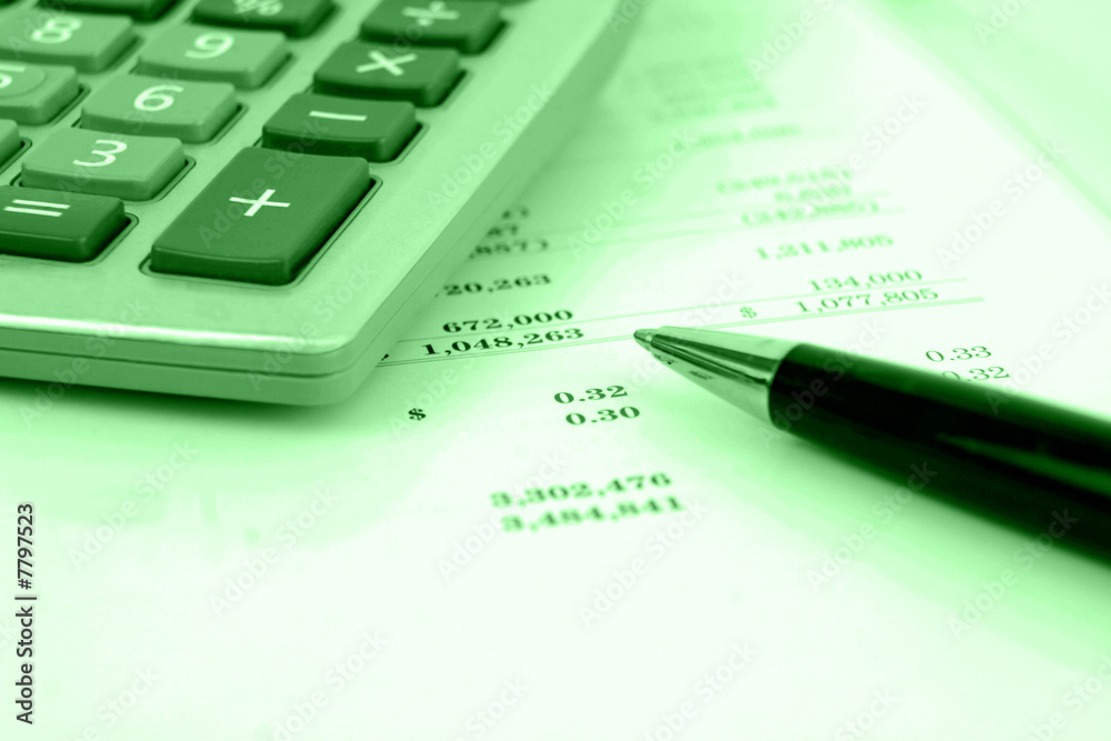 calculator on financial statement with green overlay calculator on financial statement with green overlay