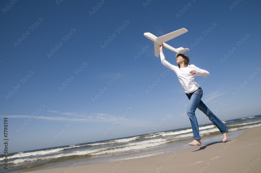 Obraz premium Teenager with plane on the beach