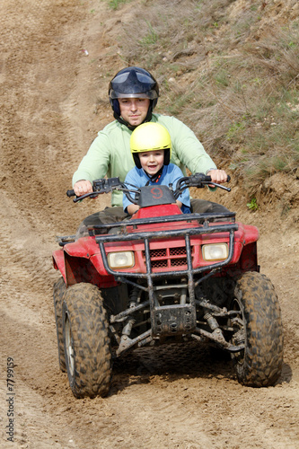 Dad with son riding a quad bike