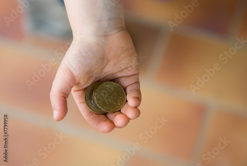 Main d'enfant tenant des pièces de monnaie