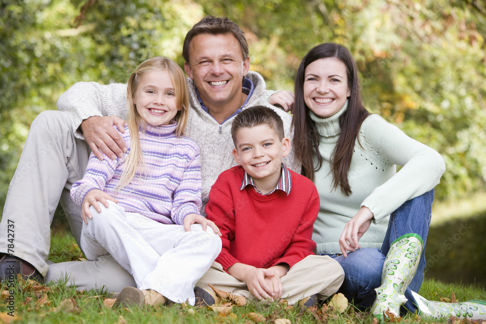 Family sitting amongst autumn trees