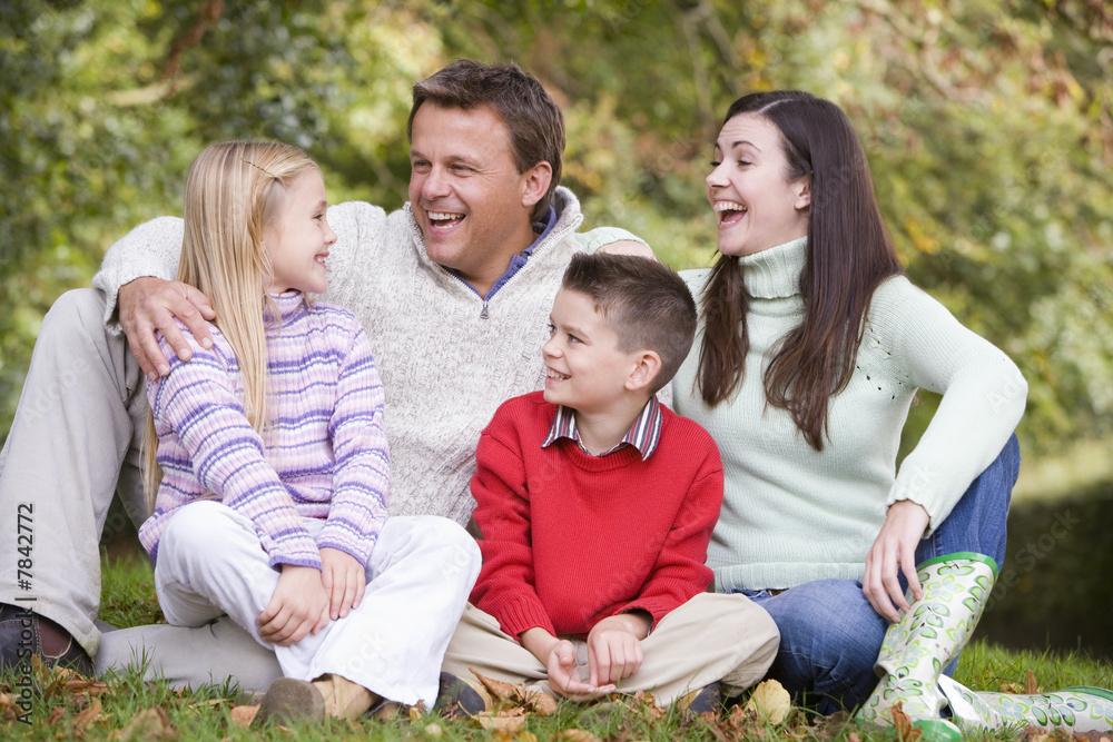 Family relaxing in autumn woodlands