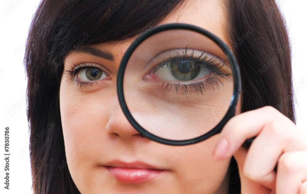 Girl's eye magnified through magnified glass on white Girl's eye magnified through magnified glass on white