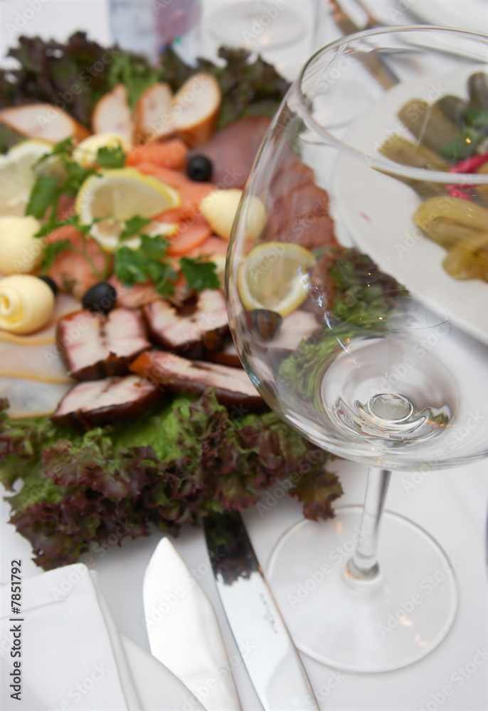 Empty glass and plate with fish viands Empty glass and plate with fish viands